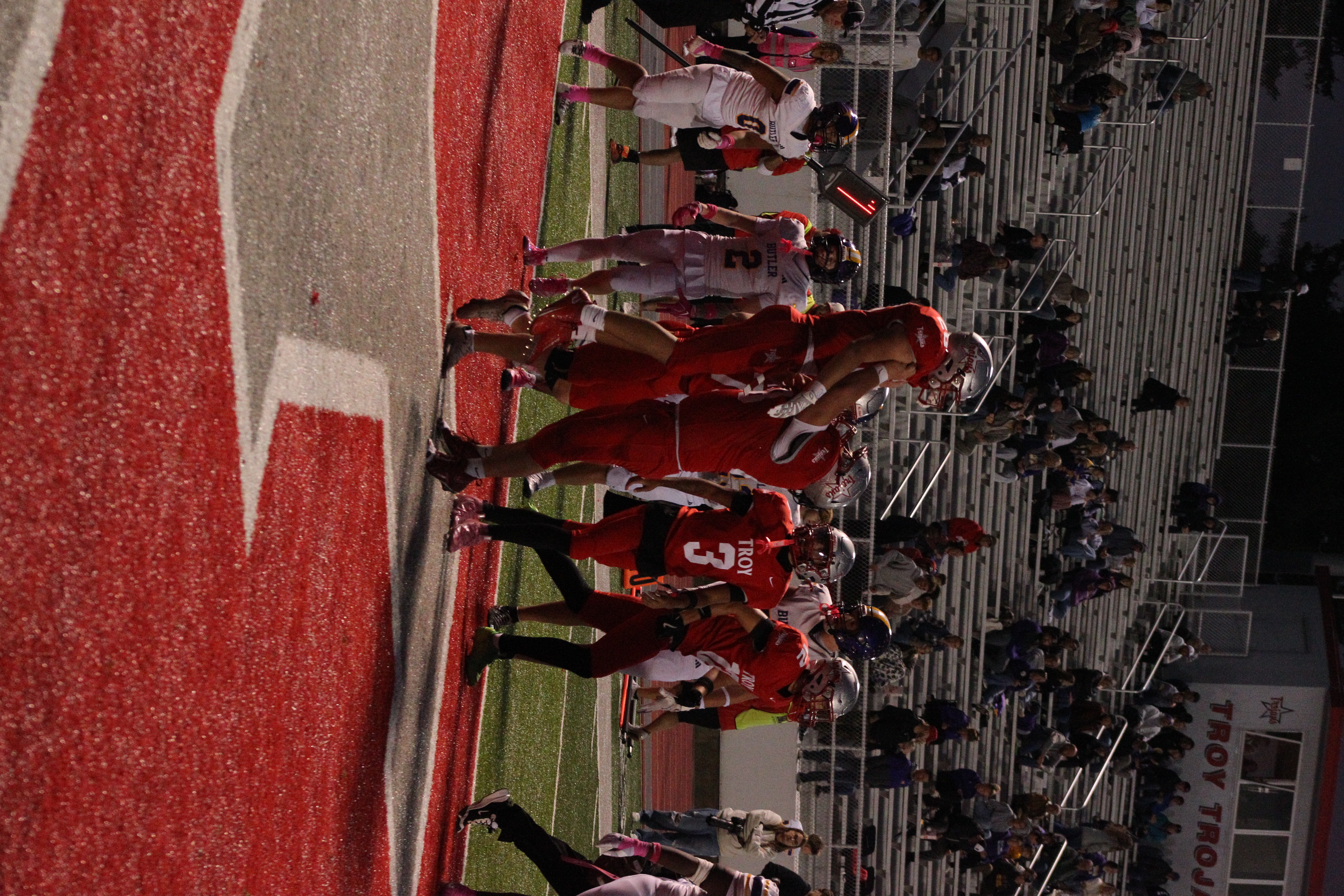 Trojans football player number 68 lifting teammate number 28 after a play